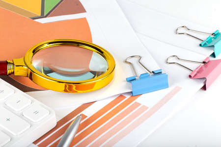 Many charts, diagram and magnifying glass. Business concept