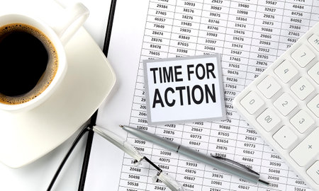 TIME FOR ACTION text on sticky on the chart with coffee, pen and calculatorの写真素材