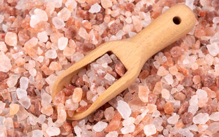 Himalayan pink salt in a spoon on a salt background close-up.の写真素材