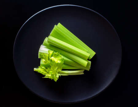 fresh celery on blackplate on the black backgroundの写真素材