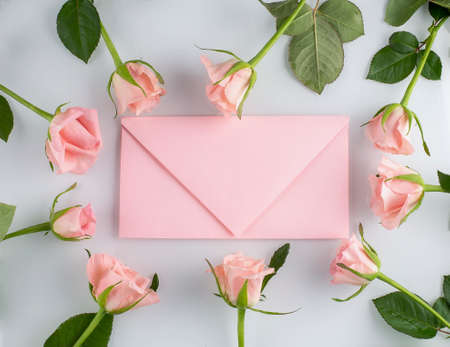 Pink roses and pink envelope on the white background, copy spaceの写真素材
