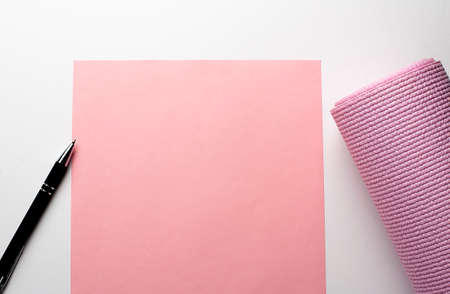 Pink gym Mat and pink paper on the white background. The concept of sports lifestyle. copy spaceの写真素材