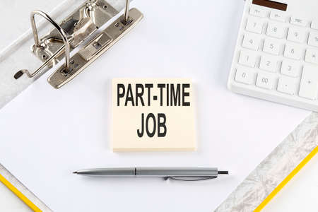 PART-TIME JOB - business concept, message on the sticker on the folder background with calculatorの写真素材