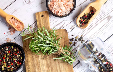 Composition with different spices,rosemary ,himalayan salt and wooden spoons on the wooden backgroundの写真素材