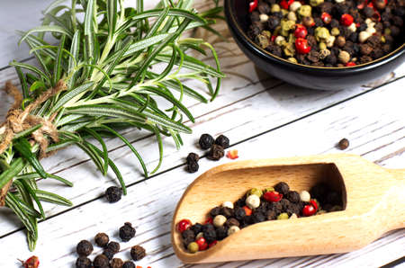 Fresh organic rosemary and pepper on wood background