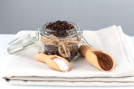 Body scrub of ground coffee with sea salt and oil on the white table background.Homemade cosmetics