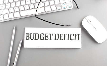BUDGET DEFICIT text on a paper with keyboard on gray backgroundの写真素材