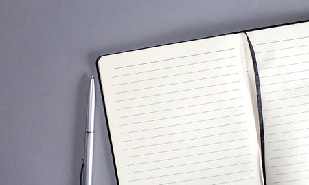Overhead above close up notebook with pen on a gray color desk