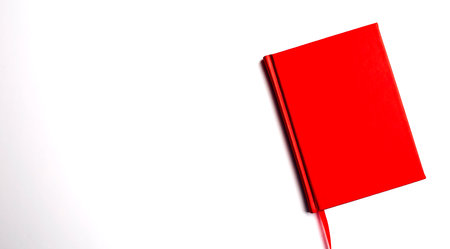 Red closed notebook mockup isolated on white background, copy spaceの写真素材