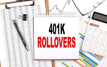 401K ROLLOVERS text on a notebook with chart, calculator and penの写真素材