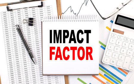 IMPACT FACTOR text on a notebook with chart, calculator and penの写真素材