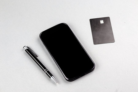Online shopping concept. Smartphone with credit card on a gray background
