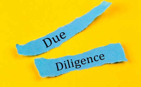 DUE DILIGENCE text on blue pieces of paper on yellow background, business conceptの写真素材