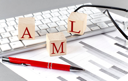 AML written on a wooden cube on the keyboard with chart on a gray backgroundの写真素材