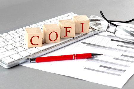 COFI written on wooden cube on the keyboard with chart on gray backgroundの写真素材