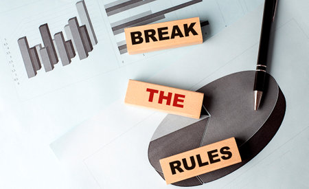 BREAK THE RULES text on a wooden block on chart backgroundの写真素材