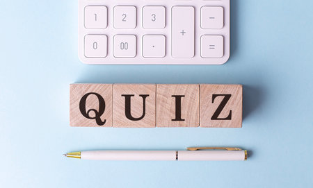 QUIZ on a wooden cubes with pen and calculator, financial conceptの写真素材
