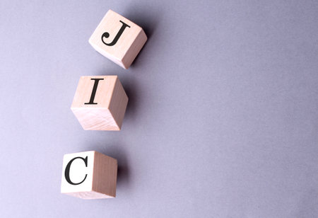 Word JIC on a wooden block on the gray backgroundの写真素材