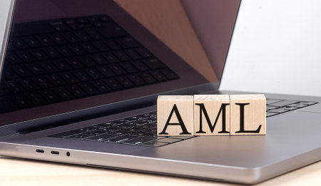 AML word on a wooden block on laptop, business conceptの写真素材