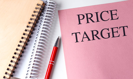 Price target text on pink paper with spiral notebooks and red pen on a white background.の写真素材