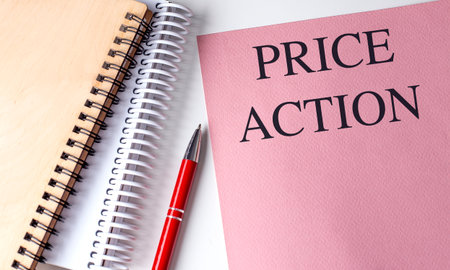 Notebook with a pink cover showing text price action next to spiral notepad and red pen.