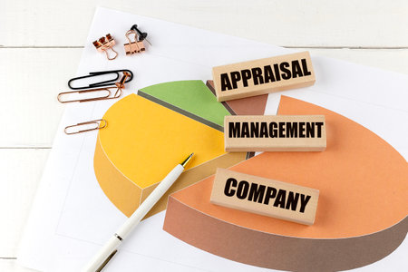 Wooden blocks with a text appraisal management company on pie chart with pen and paper clips.の写真素材