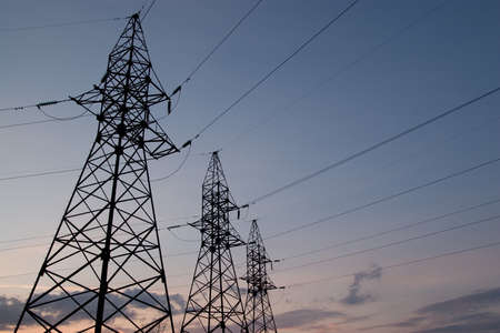 Electric pylons with cables on sunset backgroundの写真素材