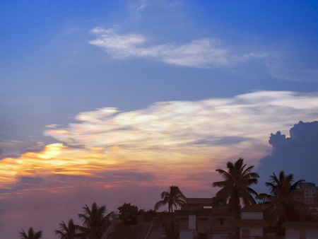 Colorful Sunset with multiple colors of sunlight glow over the country side with a silhouette of coconut trees at the horizon.の写真素材