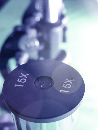 Microscope eyepiece and blurred Microscopes in a row in the backの写真素材