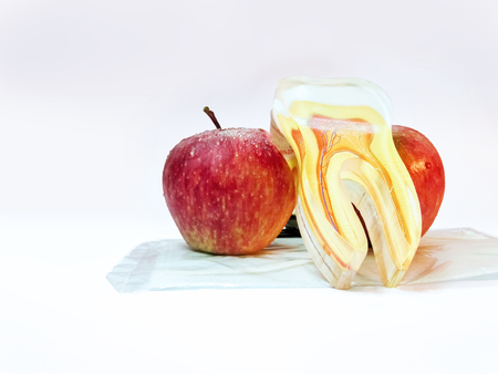 Two Apples and an artficial tooth.Apple good for dental health.An apple  a day keep the doctor away.