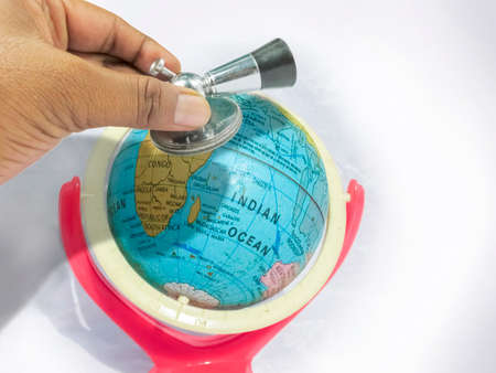 Care the Earth -a concept with a globe,stethoscope,examining hand.The globe is litle bit eroded with the time.The erosion is kept as it was to illustrate the unhealthy condition of our Earth.の写真素材