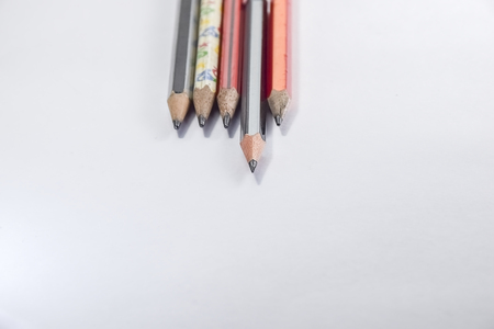 Back to school concept- a Pencil,erasor, sharpner an cut slice of the pencil on white table with or without spectacles not properly aranged isolated.の写真素材