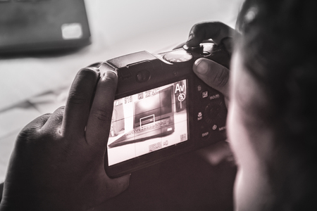 LAPTOP  IN CLOSE ENCOUNTER WITH CAMERA.CLOSE UP SHOTS OF LAPTOP ON WHITE.の写真素材