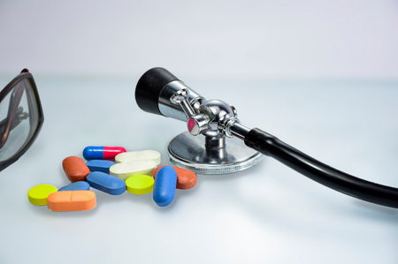 Stethoscope and colorful pills on white background. Medical concept.の写真素材