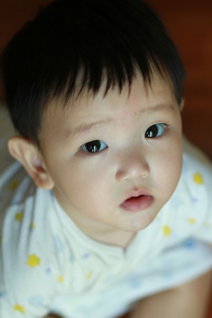 Closeup portrait of cute baby boy is looking up and thinkingの写真素材
