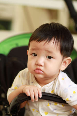 Closeup portrait of cute baby boy is looking and thinking