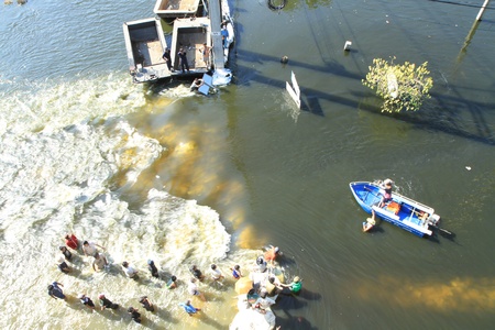 BANGKOK, THAILAND - NOVEMBER 13: Boat is passing through water barrier after barrier are destroyed during the worst monsoon flooding in decades in Bangkok, Thailand on November 13, 2011. のeditorial素材