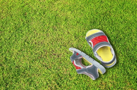 Old children shoes on green grass floorの写真素材