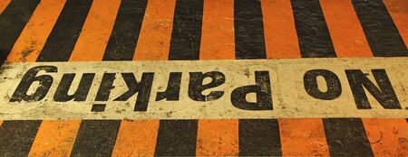 Worn and aged  NO PARKING  sign on black-yellow cracked asphalt の写真素材