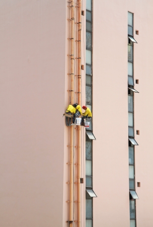 Workers working on high buildingの写真素材