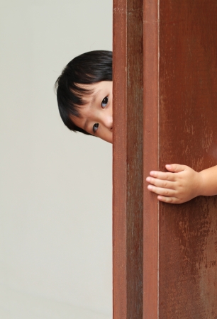 Young boy behind wooden wallの写真素材