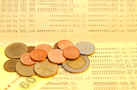 Bank saving account passbook with lot of coins above の写真素材