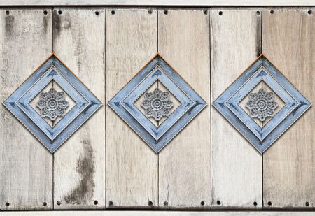 Perforated wood decorated on old wooden wall backgroundの写真素材
