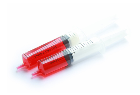 Syringe with red liquid isolated on white backgroundの写真素材