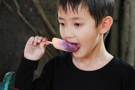 Asian boy eating ice creamの写真素材
