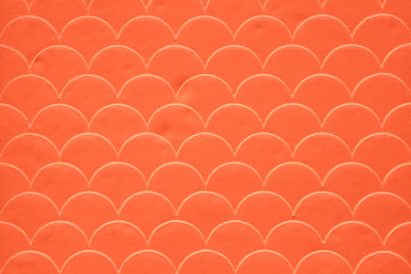 Orange fish scale seamless pattern on decorated cement wallの写真素材