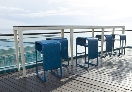 Row of blue weave bar stools with sea view in hotel or restaurantの写真素材