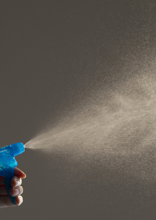Hand hold bottle spraying water