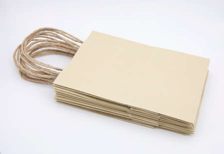 Pile of beige paper bags isolated on white background.