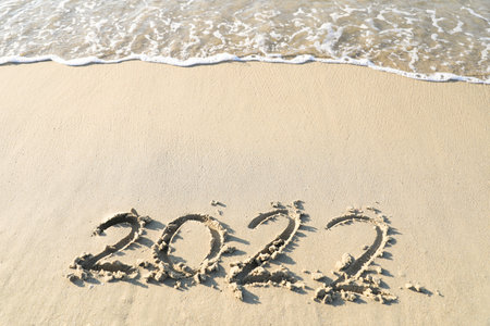 Numbers 2022 year on the sea shore, Handwritten in the sand on beach background.の写真素材